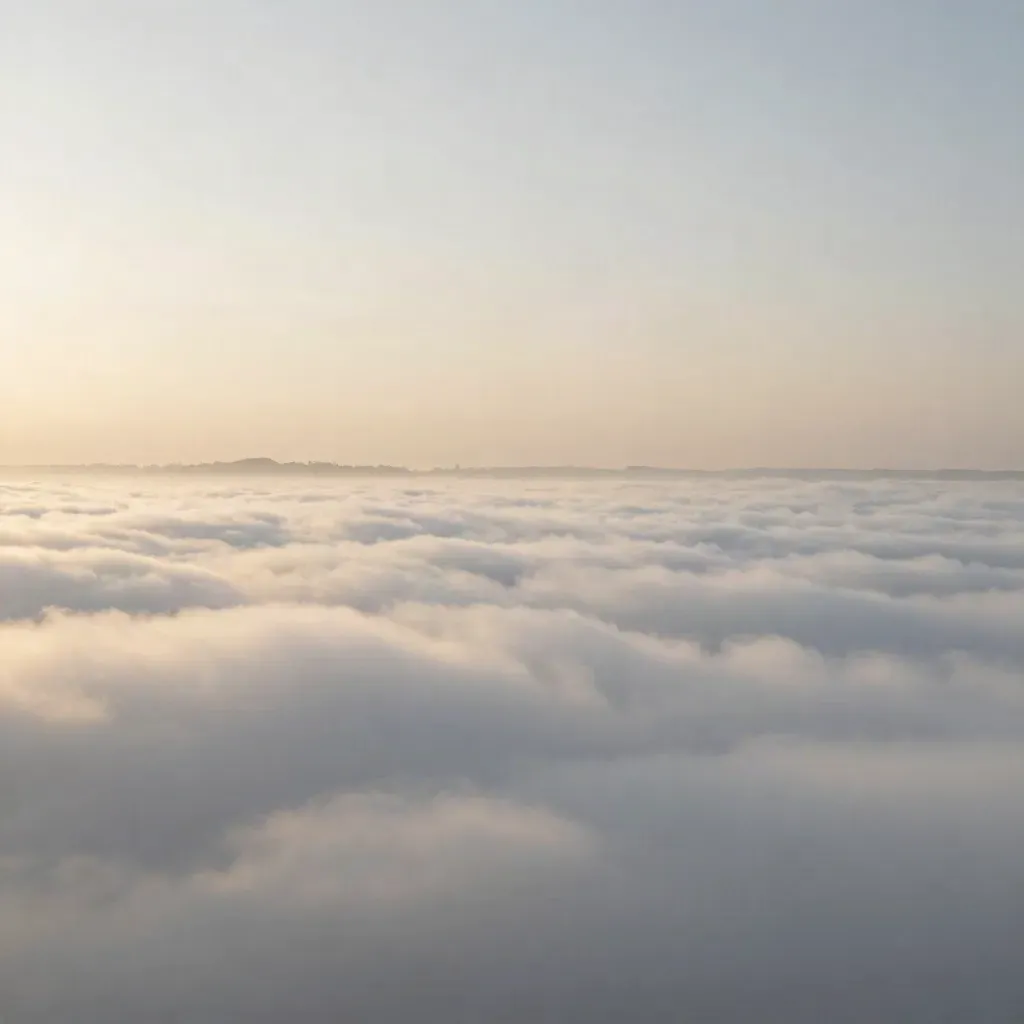 High-altitude sunrise clouds with faint city lights on the horizon.